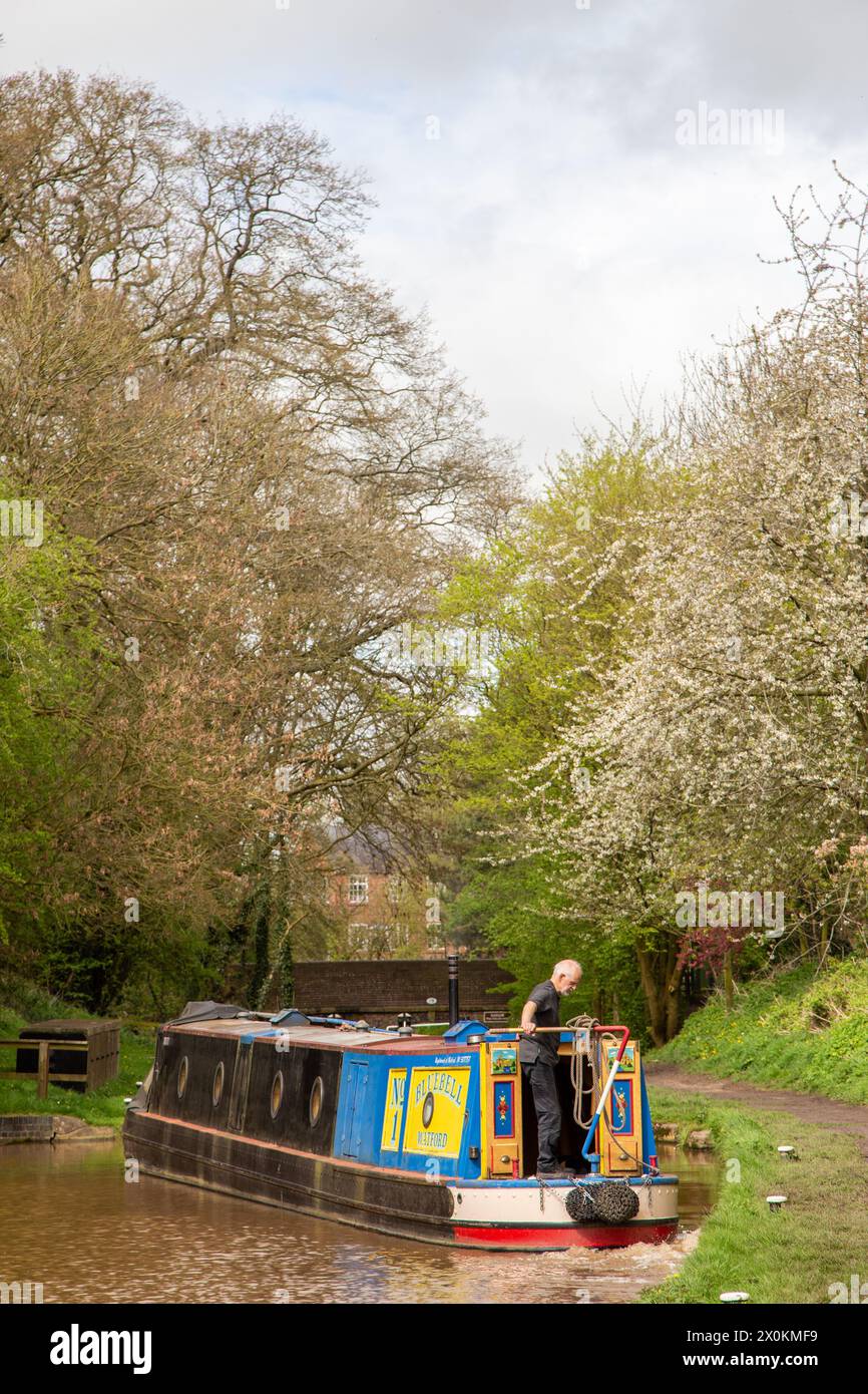 Uomo che prende un canale in barca stretta da solo attraverso chiuse sul canale Shropshire union mentre si avvicina al villaggio Cheshire di Audlem, Inghilterra, Regno Unito Foto Stock