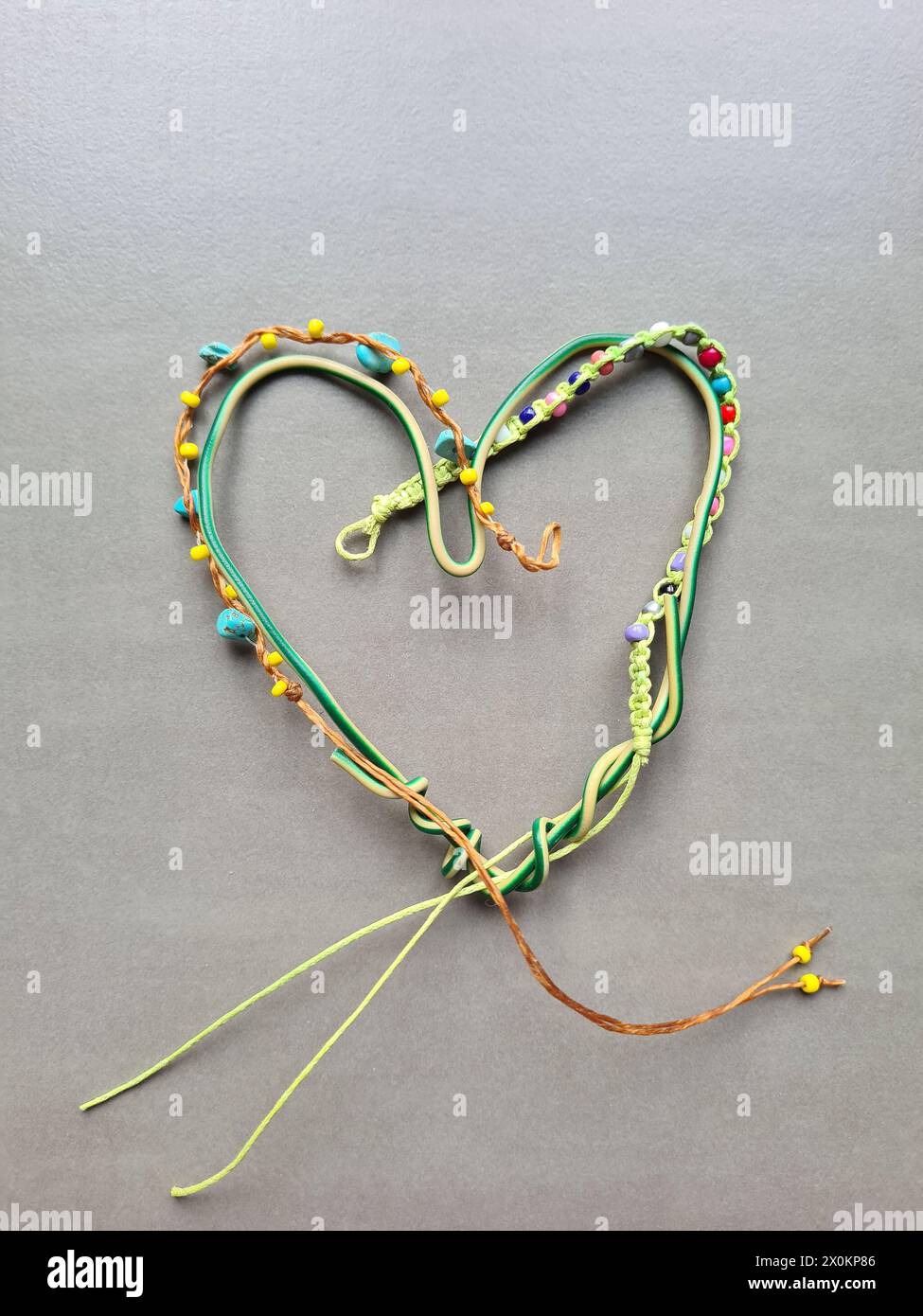 Cuore decorativo fatto in casa realizzato in filo piegato e una piccola serie di perline per creare una forma creativa del cuore Foto Stock