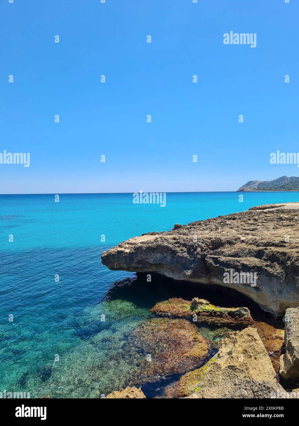 Ammira le rocce e le acque turchesi sul lungomare di Cala Ratjada in una splendida giornata estiva, Maiorca, Spagna Foto Stock