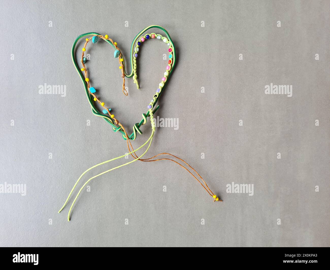 Cuore decorativo fatto in casa realizzato in filo piegato e una piccola serie di perline per creare una forma creativa del cuore Foto Stock