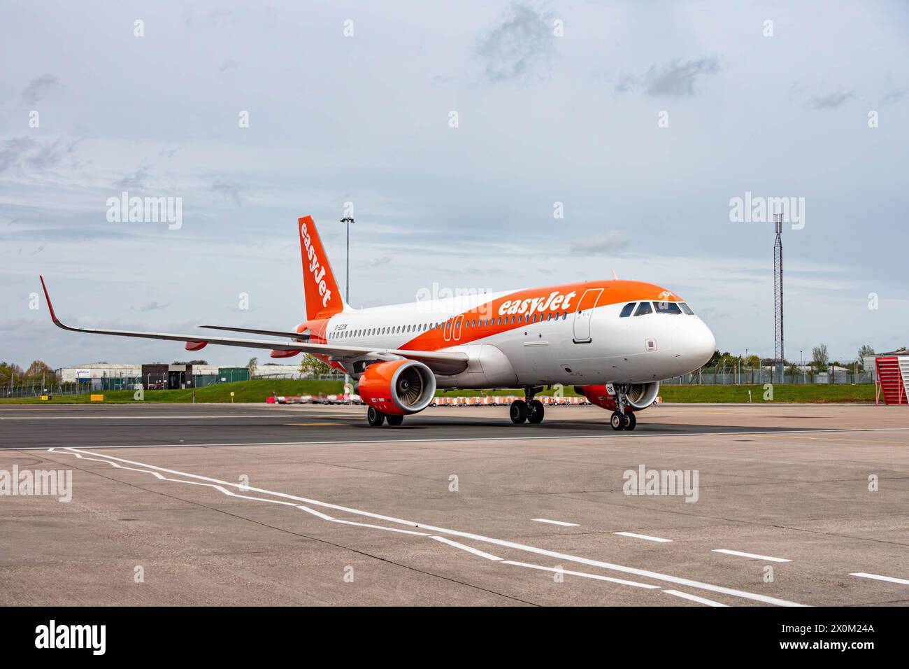 Un aeroplano easyJet con la sua caratteristica livrea bianca e arancione che ruba all'aeroporto internazionale di Birmingham Foto Stock