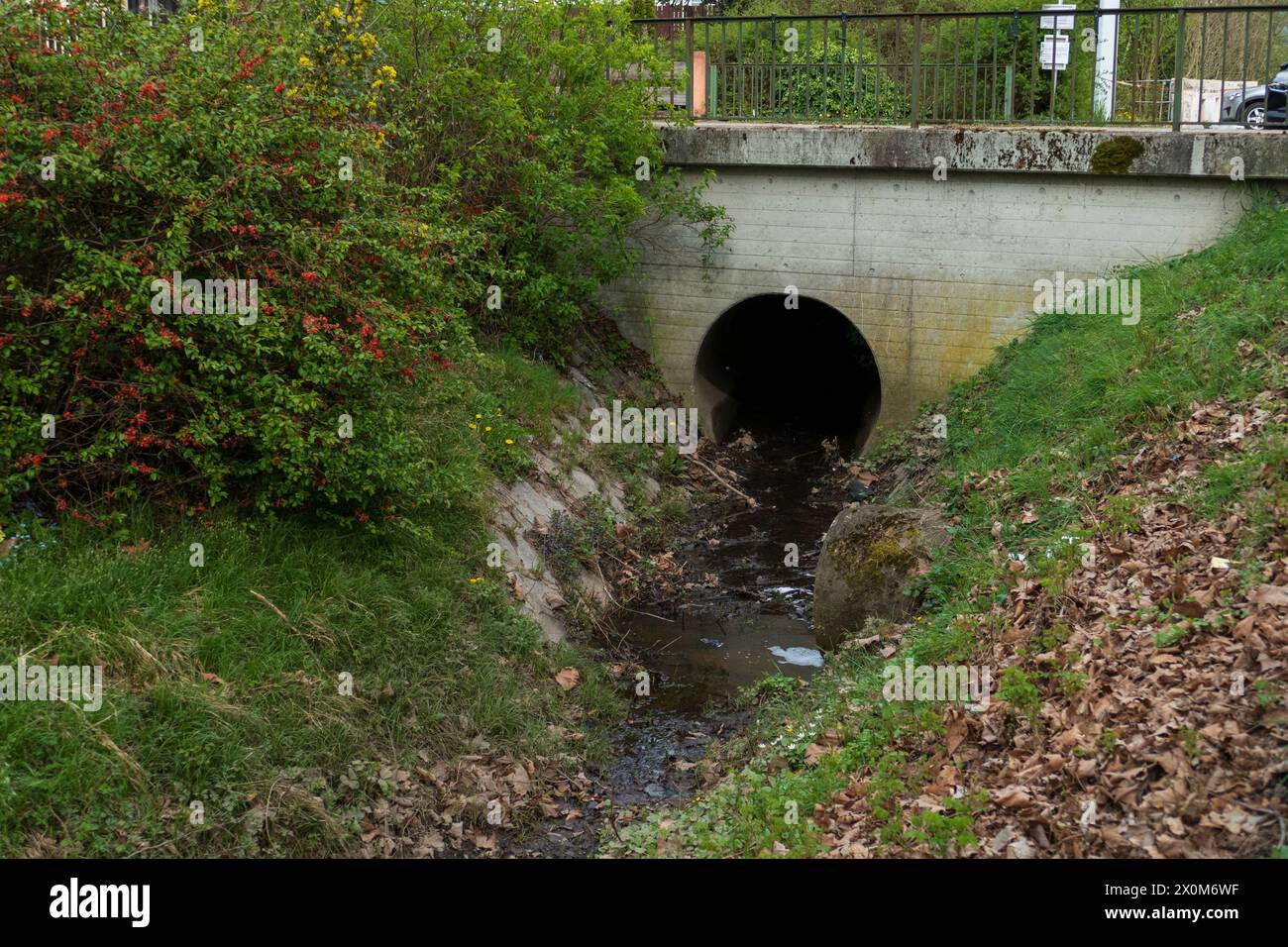 Abwasserkanal aus Beton führt Wasser in einen kleine Bach Foto Stock
