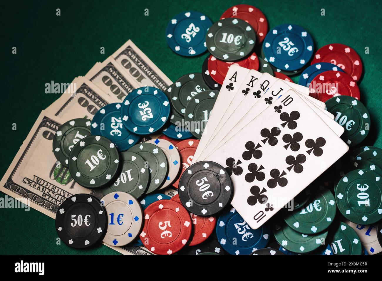 Carte con un colore reale su un mucchio di chip e denaro dollari in un gioco di poker Foto Stock