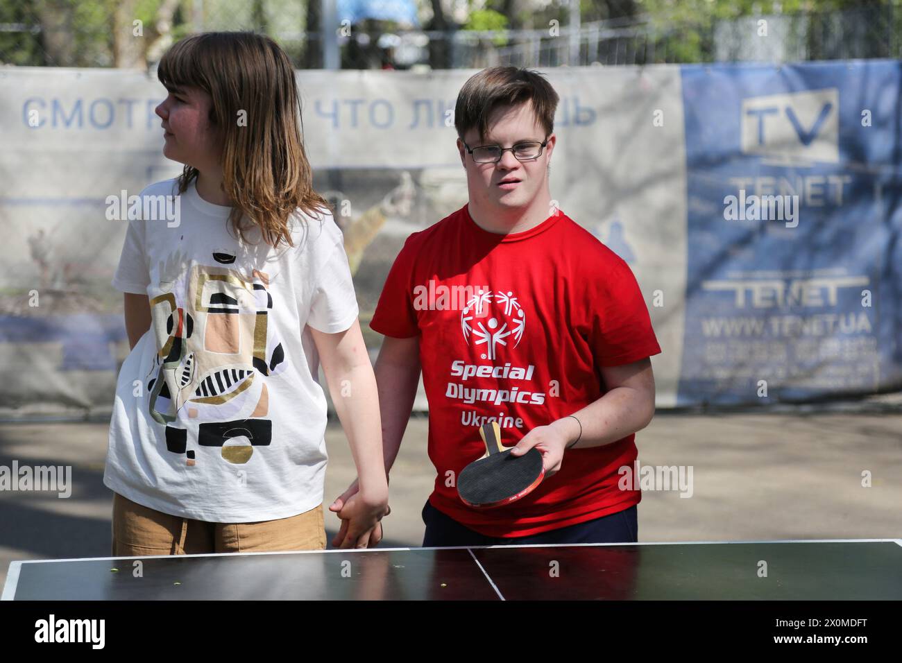 I giovani con esigenze particolari sono visti tenersi per mano mentre giocano a ping-pong in Piazza Starobazarny. Nonostante la guerra in corso con la Federazione russa, la GO 'Foundation for Special Youth of Ukraine' continua ad affrontare i problemi delle persone che hanno bisogno di cure speciali. Per prepararsi alla partecipazione alle Olimpiadi speciali sono organizzati un teatro comprensivo, una lettura con cani e attività sportive. Special Olympics è un'organizzazione internazionale che si occupa di organizzare eventi sportivi per persone con disabilità mentali. Il principale organizzatore dei Giochi Olimpici speciali, che si svolgono Foto Stock