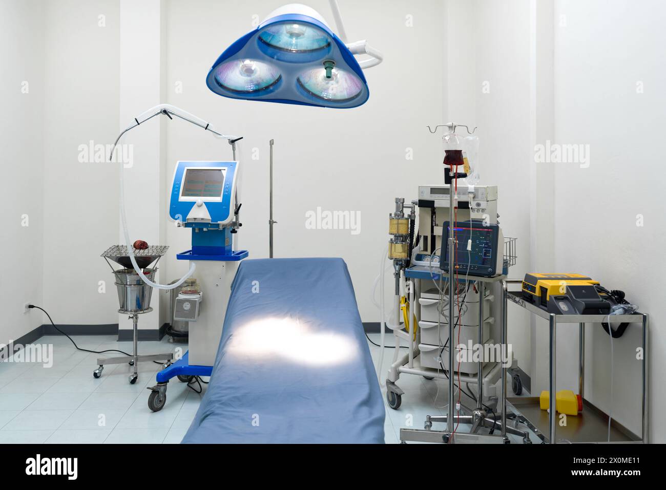 Una tipica sala operatoria in un ospedale con una lampada chirurgica sopra la testa per fornire un'illuminazione luminosa e direzionale all'équipe chirurgica durante la procedura. Foto Stock