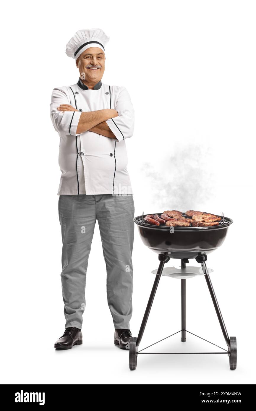 Chef accanto a un barbecue portatile isolato su sfondo bianco Foto Stock