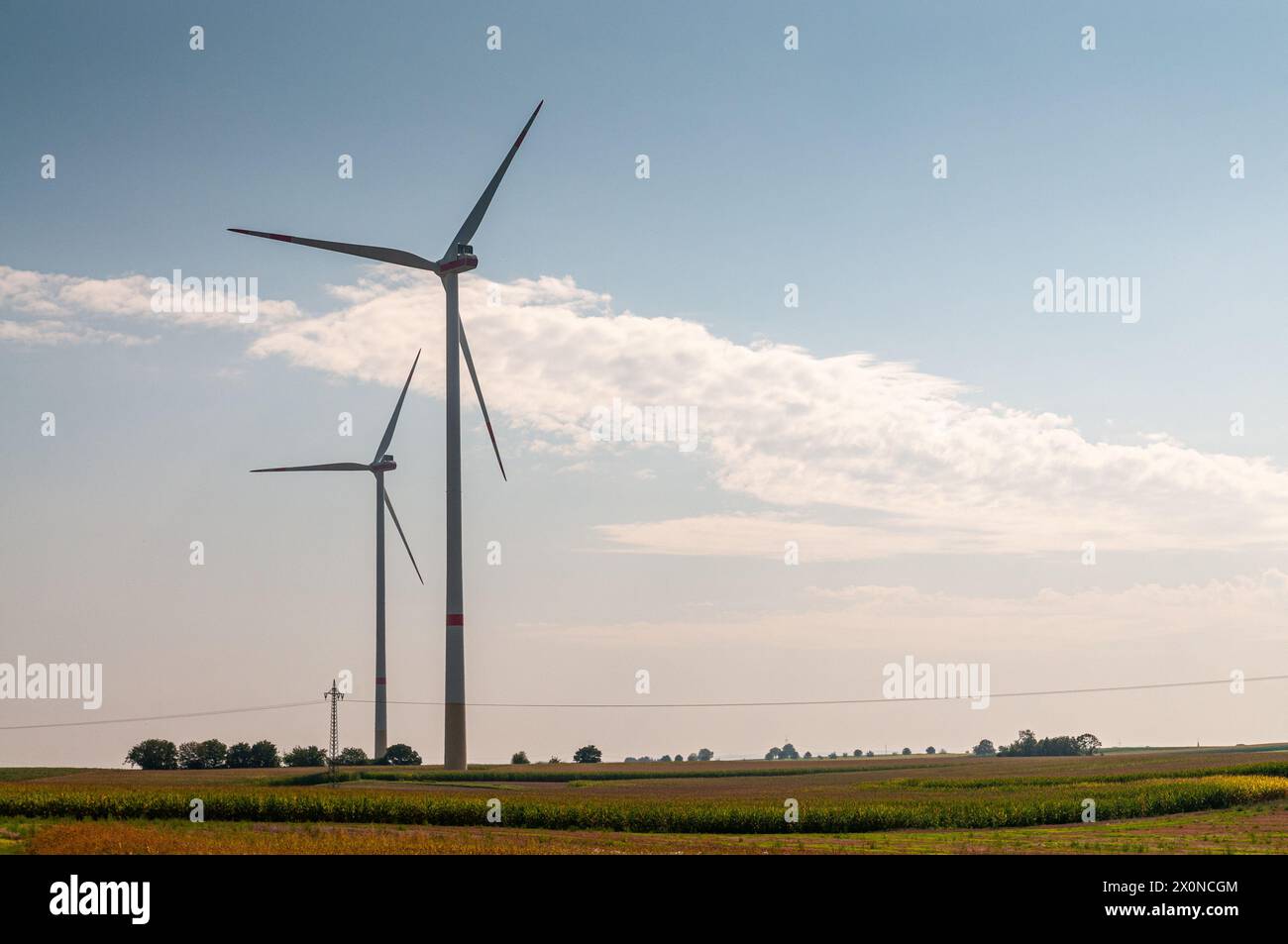 Produzione sostenibile di energia verde con turbine eoliche, in una giornata di sole con cielo nuvoloso Foto Stock
