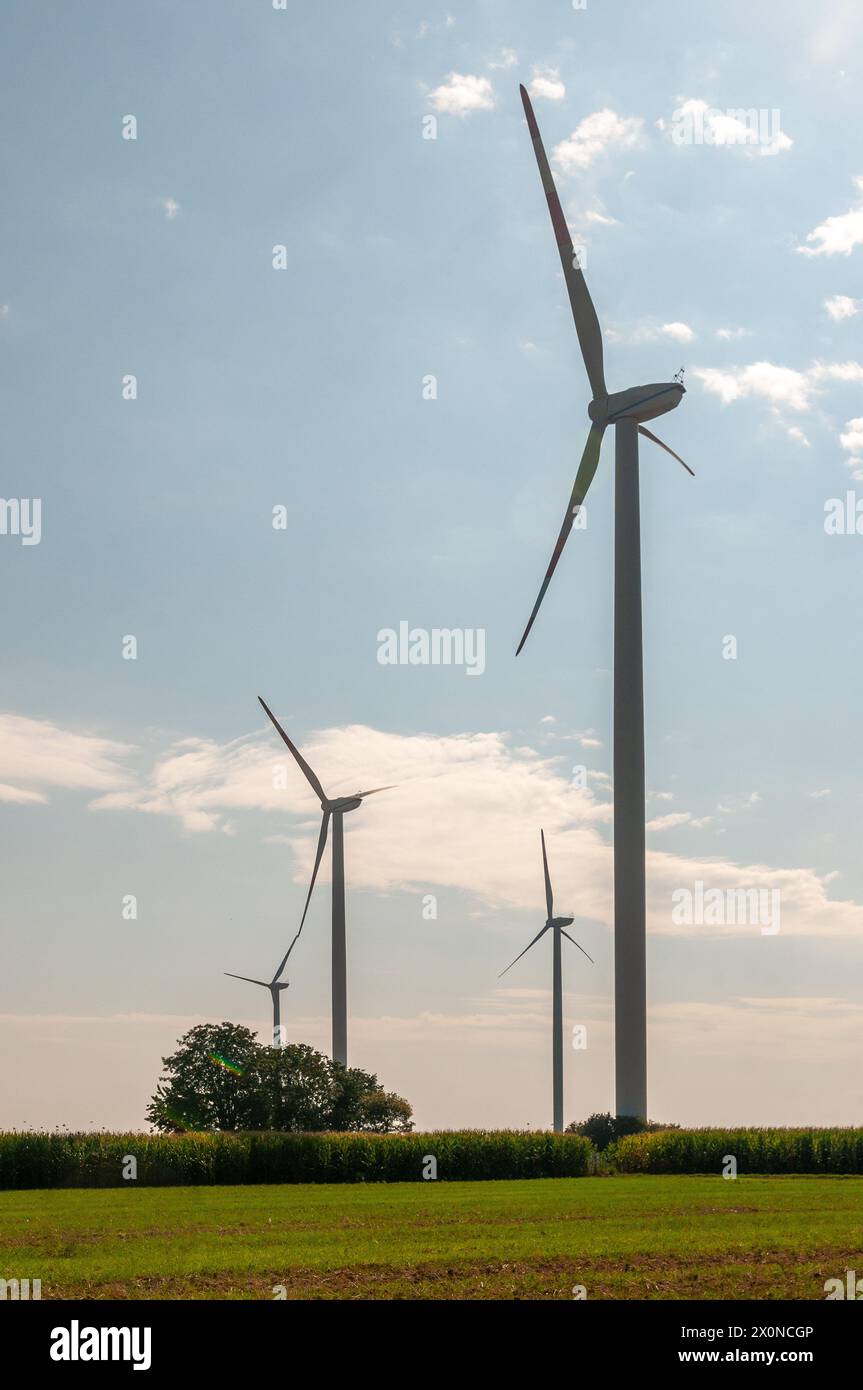 Produzione sostenibile di energia verde con turbine eoliche, in una giornata di sole con cielo nuvoloso Foto Stock