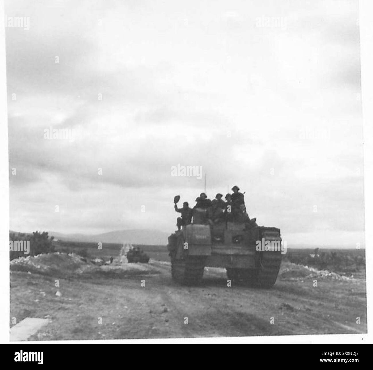 I carri armati Churchill avanzano nella Terra di No Man durante la campagna del Nord Africa con i Royal Engineers che cavalcano sull'armatura, segnando la loro prima azione nel teatro. Foto Stock