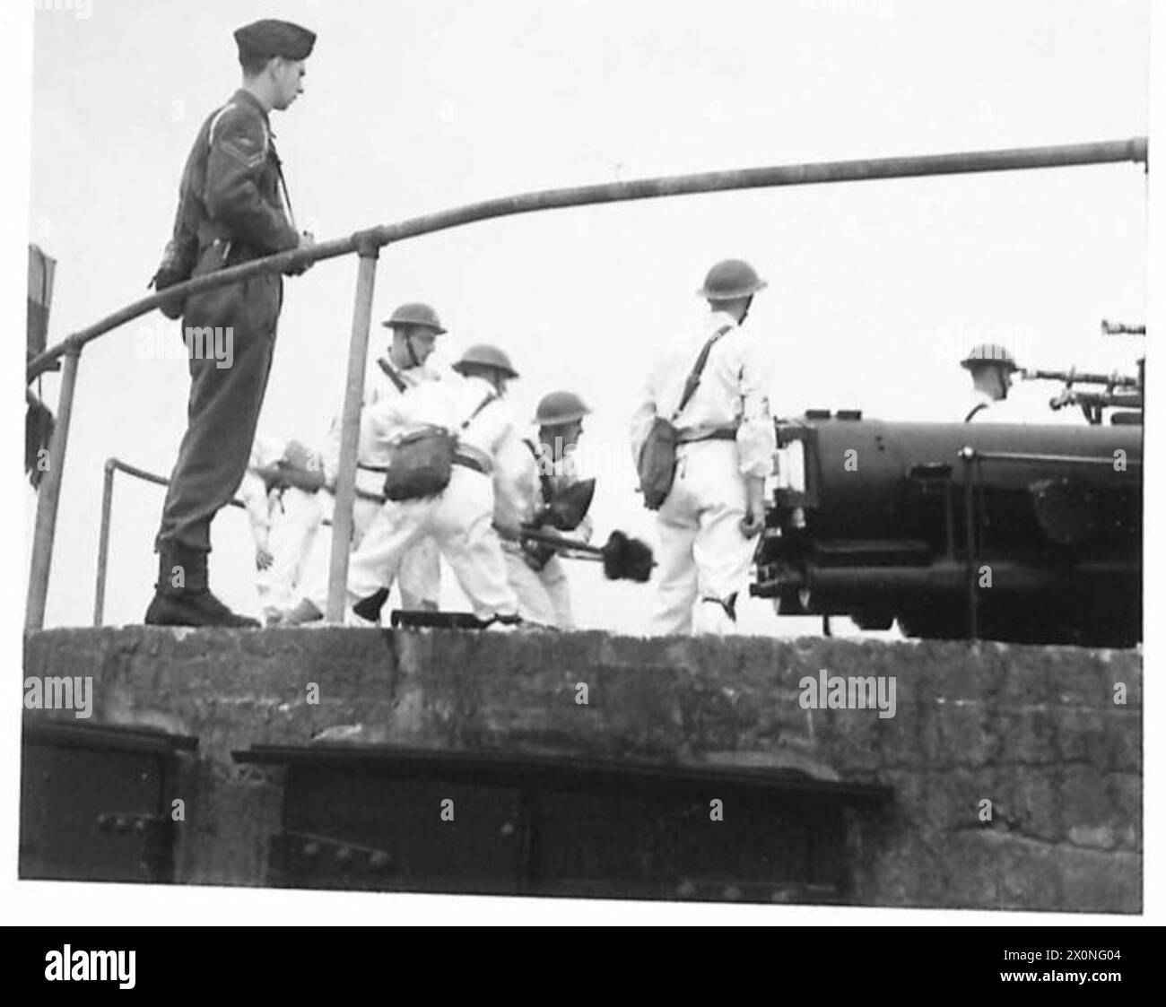IN Una SCUOLA DI ARTIGLIERIA COSTIERA, l'equipaggio di un cannone da difesa costiera da 15 cm in azione. Negativo fotografico, British Army Foto Stock