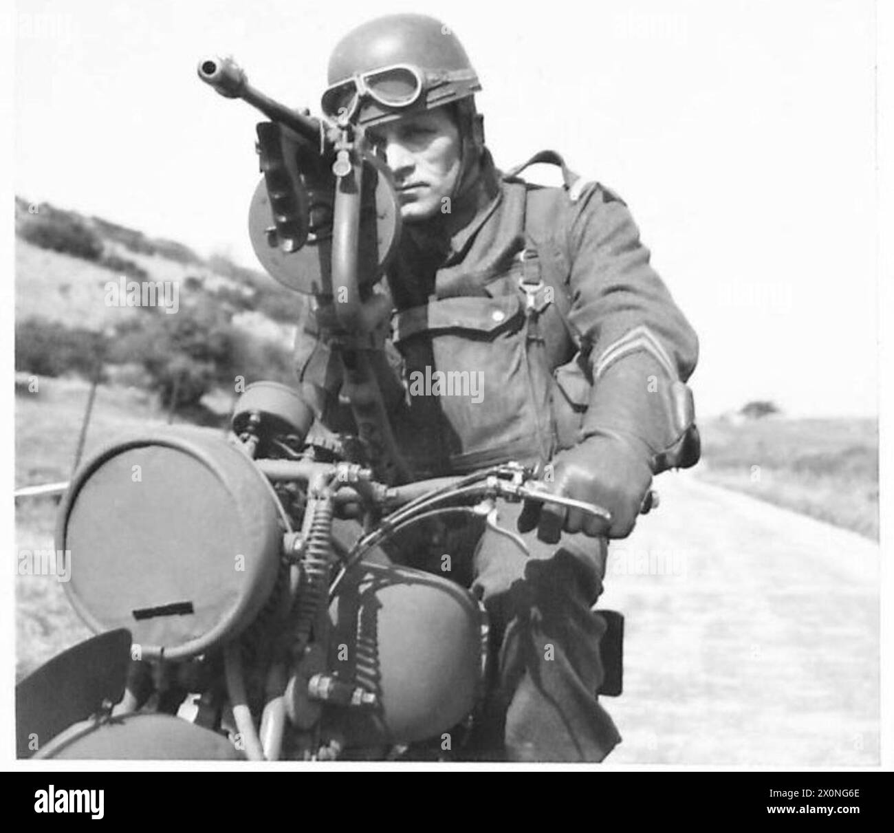 Un guardiano gestisce una motocicletta dotata di una pistola Tommy, dimostrando mobilità e capacità di pattuglia armata. Foto Stock