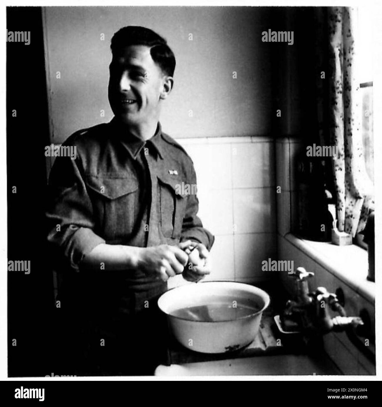 Un soldato dell'Ottava Armata in congedo svolge compiti di cucina, sbucciando le patate in preparazione di una festa. Foto Stock