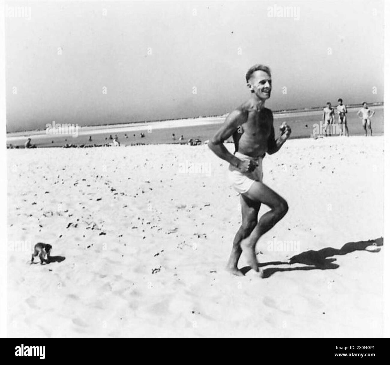 Un soldato corre lungo la spiaggia prima di fare il bagno con le altre truppe durante le attività dell'esercito britannico dal deserto al mare. Foto Stock