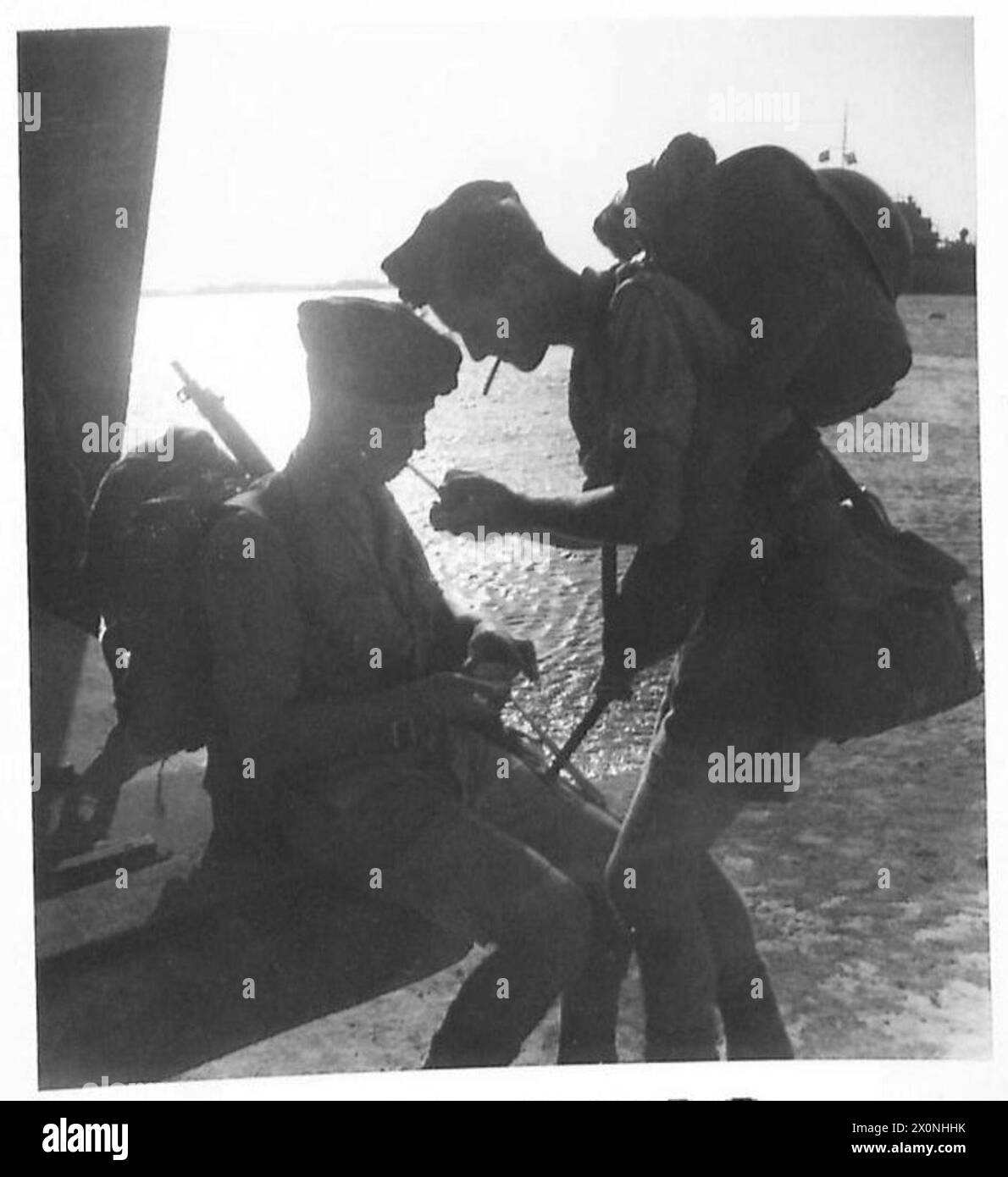 PREPARATIVI PER L'INVASIONE A TRIPOLI - le truppe sono state imbarcate a tutte le ore del giorno e della notte, qui due uomini sono visti godersi un'ultima sigaretta prima di un imbarco tardivo. Negativo fotografico, British Army Foto Stock
