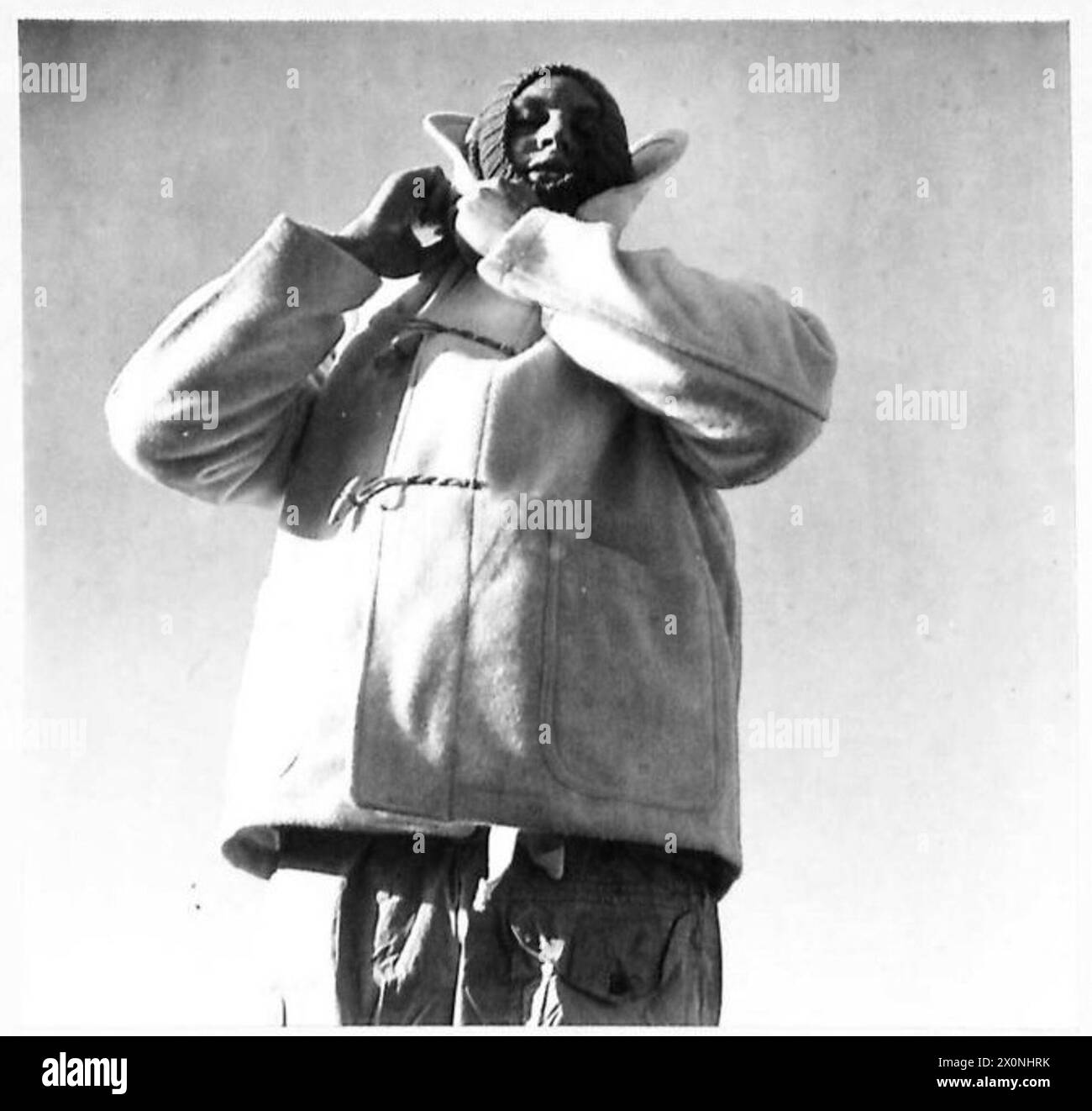 Un cappotto bianco senza cappuccio è indossato come parte dell'abbigliamento invernale consegnato alle forze dell'ottava armata britannica in Italia. Foto Stock