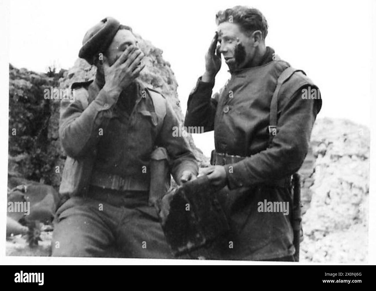Fotografia del personale dell'esercito britannico che si prepara per una pattuglia notturna, con un bicchierino in Nord Africa, Sicilia, Italia, Balcani e Austria, 1942-1946. L'immagine è un negativo fotografico. Foto Stock