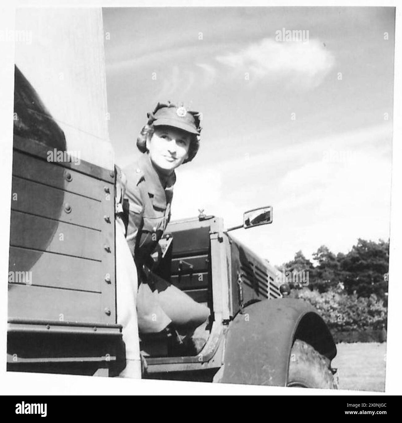 Un primo piano di un autista del servizio territoriale ausiliario viene mostrato in un convoglio, evidenziando il personale e il funzionamento del veicolo, in un negativo fotografico dell'esercito britannico. Foto Stock