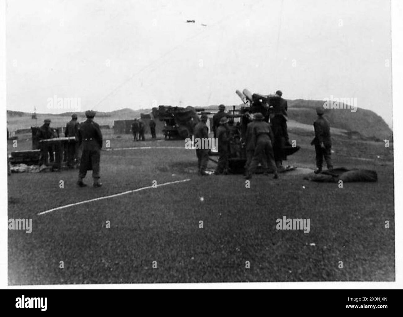 Fotografia di un cannone antiaereo del 3,7 in un campo di allenamento in Scozia che si prepara a sparare contro una manica trainata. L'immagine è un negativo fotografico dell'esercito britannico. Foto Stock