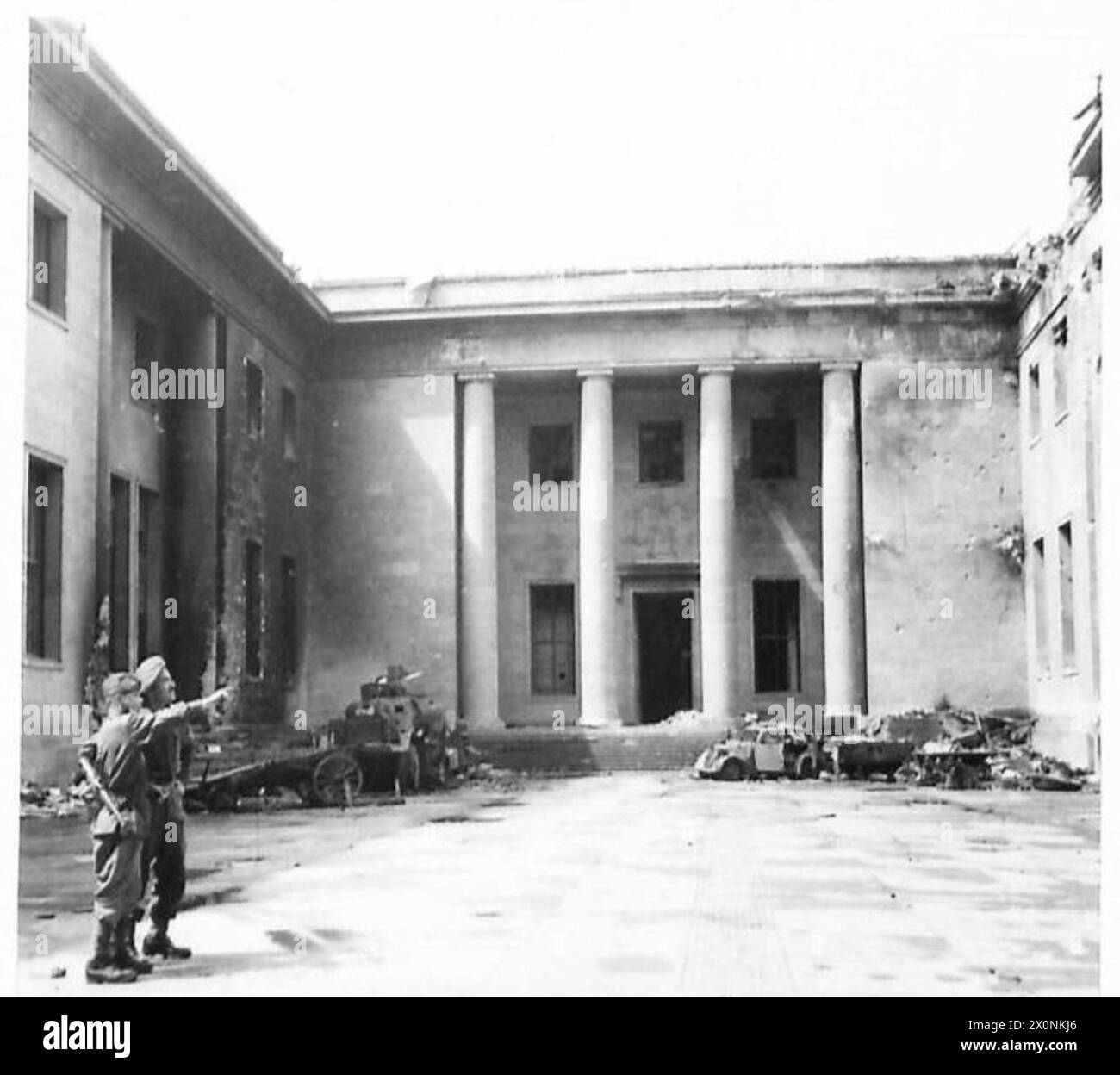 Un soldato britannico si trova con un giovane russo nel cortile della Cancelleria del Reich a Berlino, il sito storico associato al comando di Hitler durante la battaglia di Berlino. Foto Stock