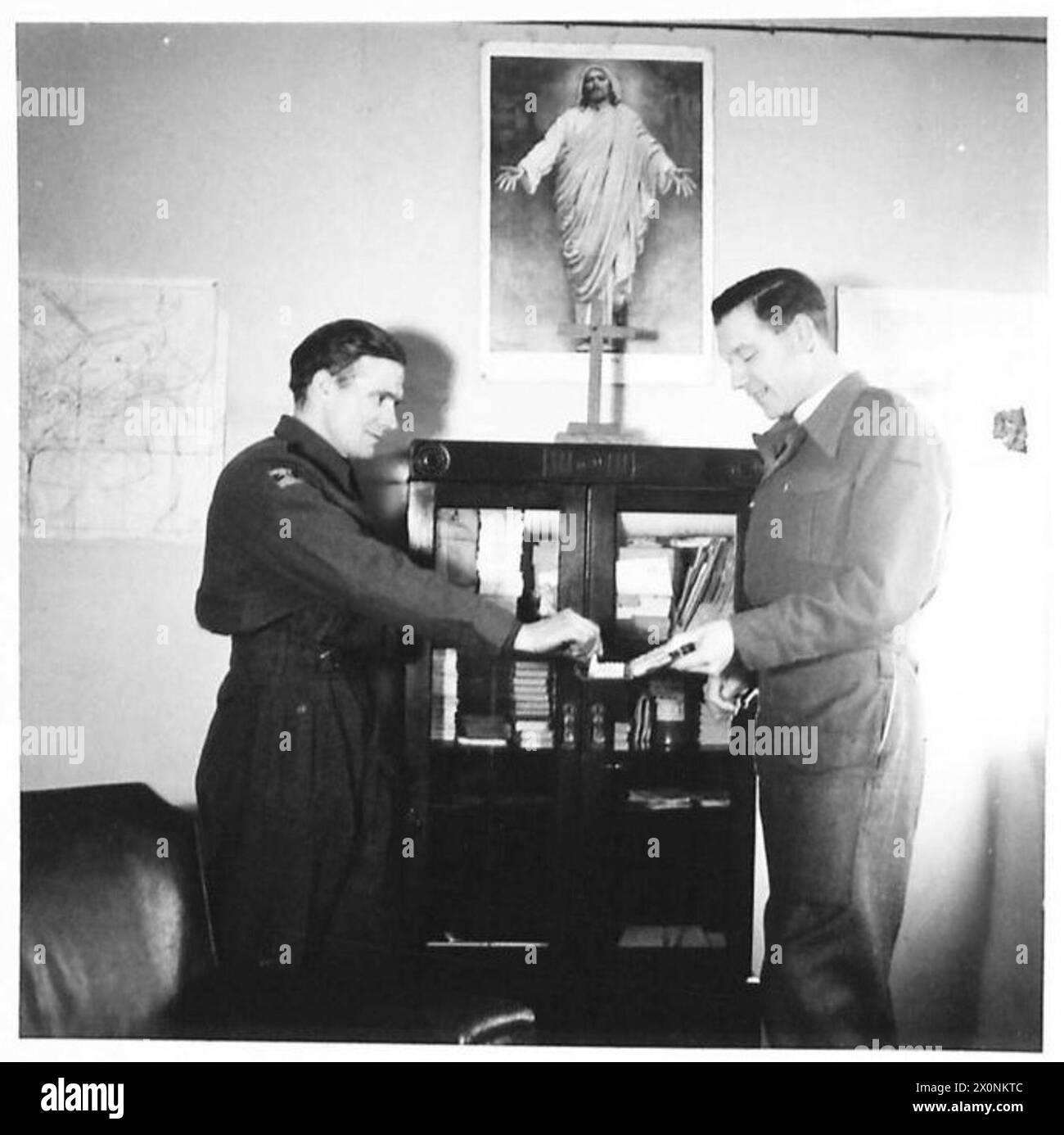 Il Rev. R. Smith, padre dell'esercito, intervista un soldato e offre una sigaretta, raffigurando la cura pastorale di routine e l'interazione con il personale militare. Foto Stock