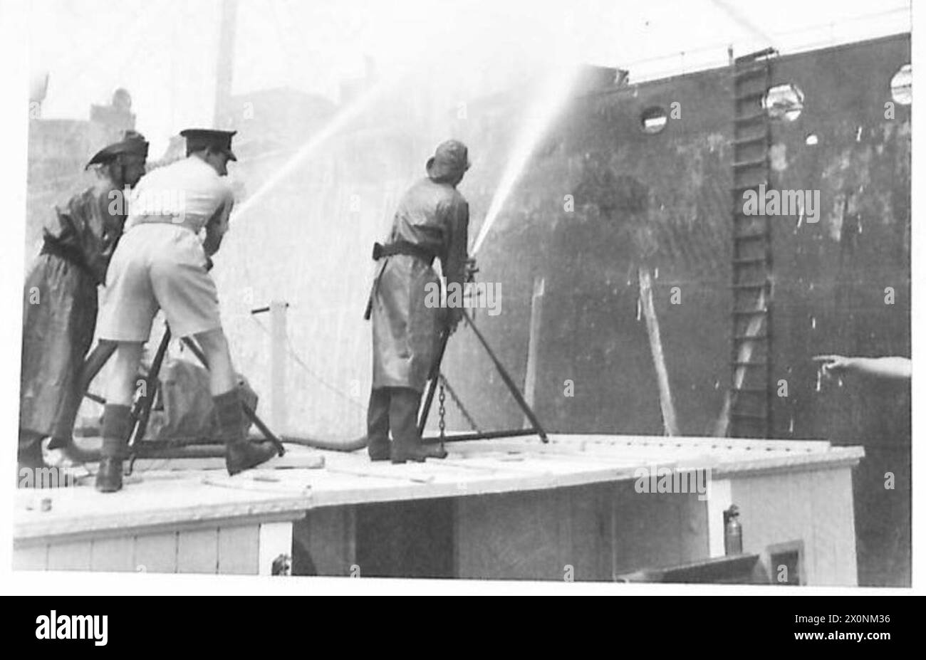 Fotografia che mostra i vigili del fuoco dell'esercito britannico che praticano l'estinzione di un incendio su un relitto usando manichette, acqua e schiuma. Foto Stock