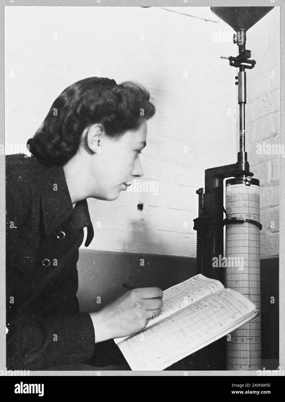Il principale Aircraftwoman Gwen Nunns della RAF Meteorological Section a Worthing legge un anemometro che registra la direzione del vento a 50 metri sopra il tetto di una stazione RAF nel 1945. Foto Stock