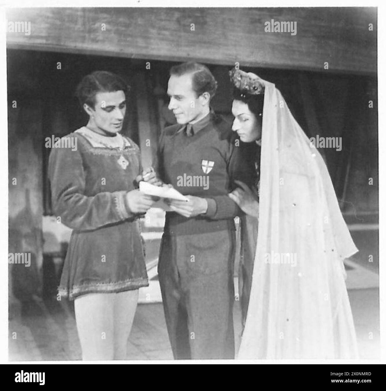 Il produttore recensisce una sceneggiatura con artisti, tra cui il capitano G. Leaman nel ruolo di Ali Baba, in un'attività teatrale dell'Eighth Army, catturata in un negativo fotografico dell'Esercito britannico. Foto Stock