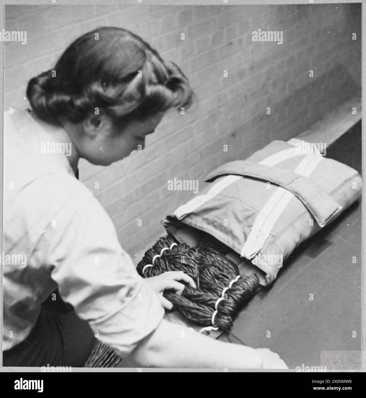 I paracadute dei WAAF vengono inseriti tirando i cavi nelle tasche ad anello sulla patta interna della confezione, 1942. Foto Stock