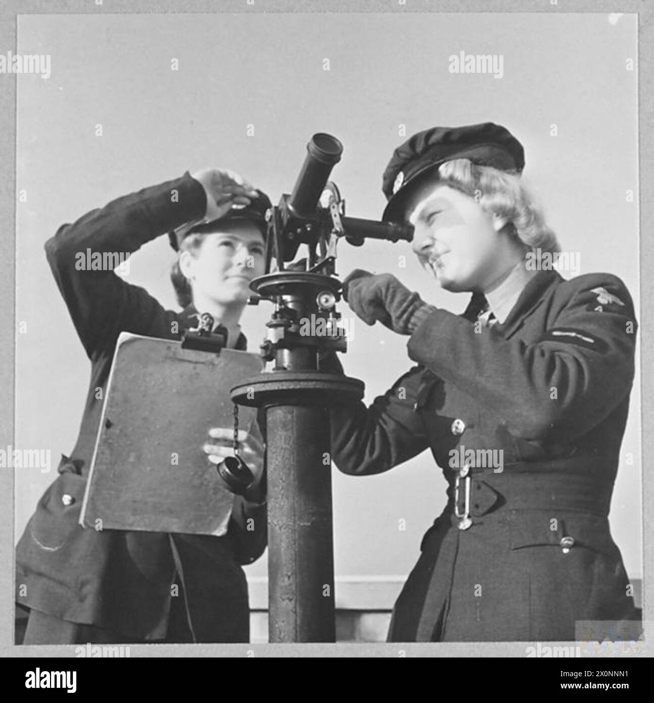 Fotografia che mostra il personale di W.A.A.A.F. che stima la velocità del vento rilasciando un pallone e tracciandone la rotta con una teodolite. L'immagine è un negativo fotografico emesso dalla RAF. Foto Stock