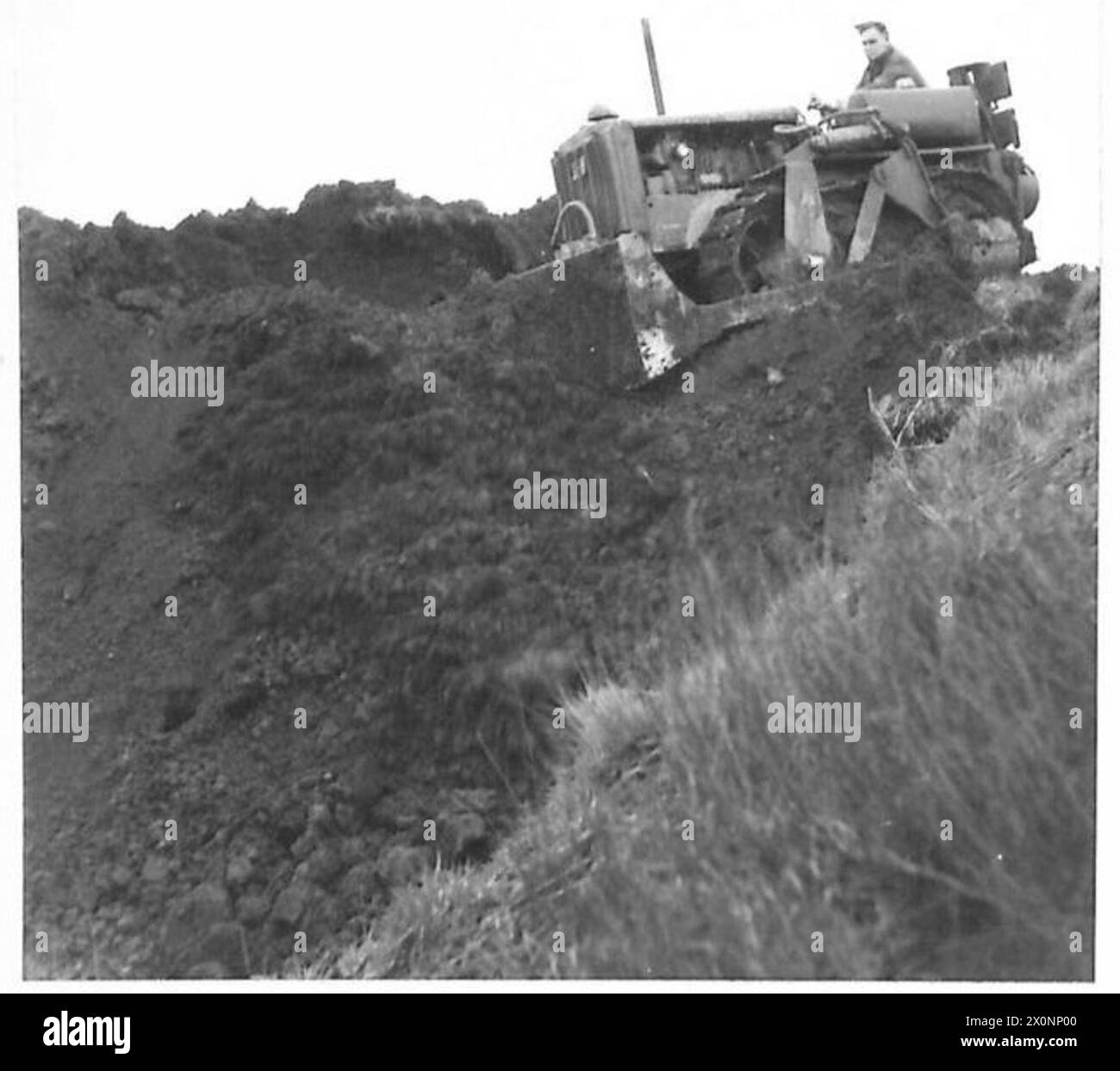 Un bulldozer americano opera in un sito di cava, rimuovendo la terra dalla cima di una formazione rocciosa durante le operazioni dell'esercito britannico. Foto Stock