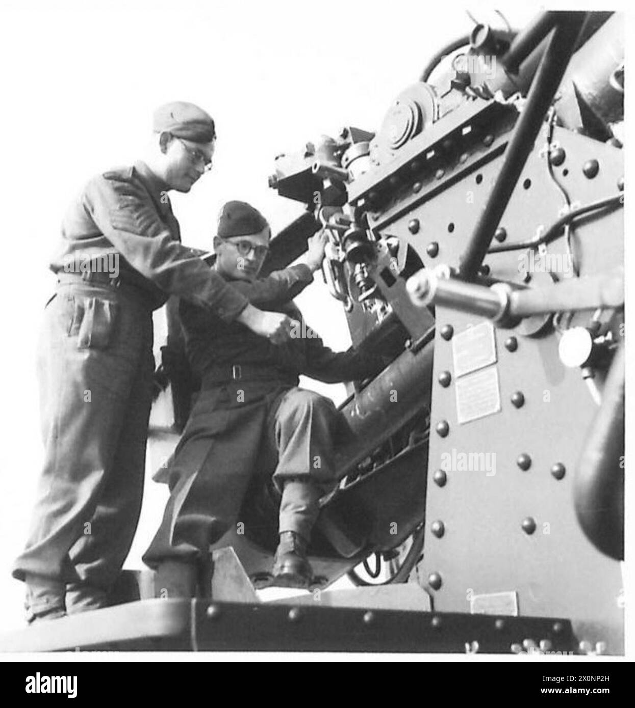Il sergente D. Tarrant istruisce il tenente E.P. Evans sul meccanismo a poppa di un cannone da 3,7 pollici durante l'addestramento antiaereo per le guardie interne. Foto Stock