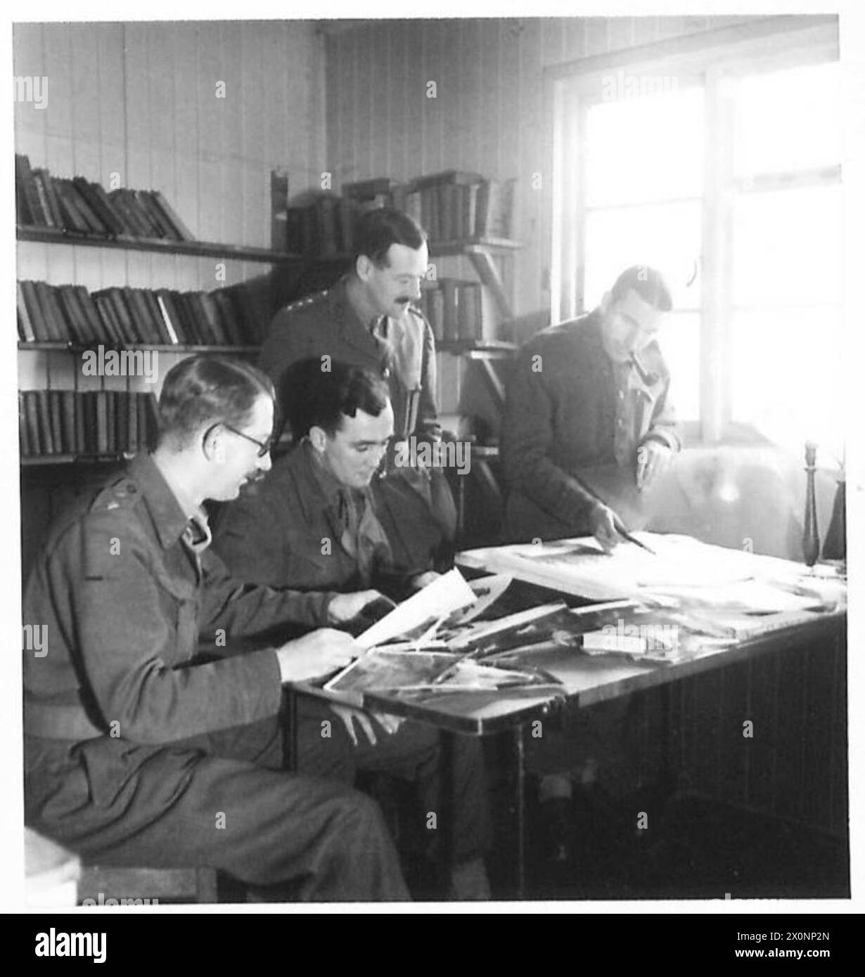 Conferenza editoriale presso il Western Command O.C.T.U., con personale espositivo che esamina le fotografie per selezionare l'organizzazione amministrativa e di formazione più adatta. Negativo fotografico, British Army. Foto Stock