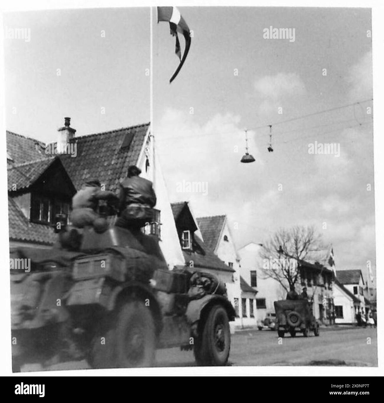 Le truppe britanniche del 21st Army Group attraversano la Danimarca sulla strada per Copenaghen, osservate dalle guardie di frontiera danesi durante il movimento post-liberazione. Foto Stock