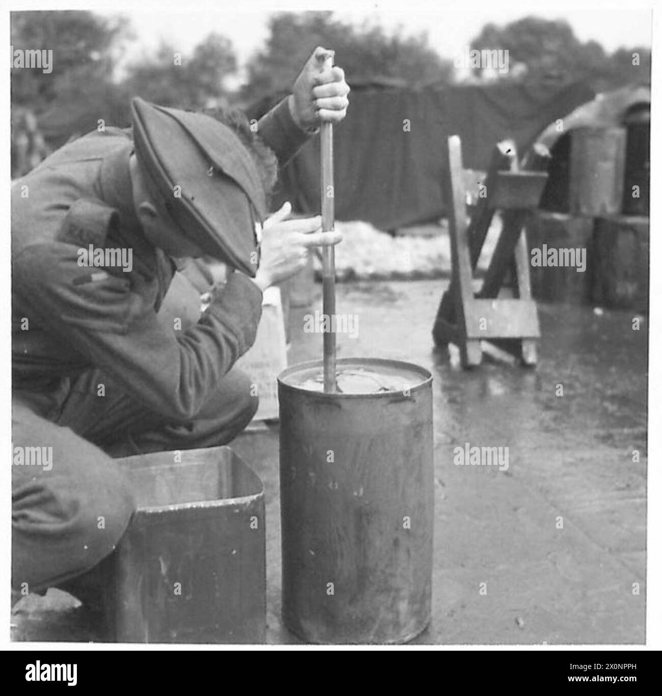 Presso il deposito di benzina N.10 di Carnforth, il personale verifica la contaminazione dell'acqua dei fusti utilizzando un tubo di vetro sigillato per osservare l'acqua alla base del tamburo mentre l'olio galleggia sulla parte superiore. Foto Stock