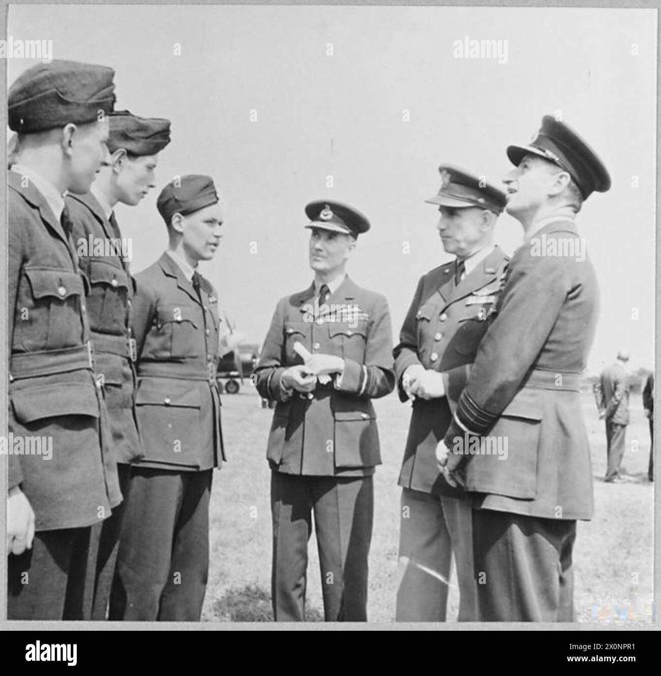 ANCORA ARRIVANO - Sir Charles Portal [giusto] con il generale Chaney [seconda destra] che parla con l'equipaggio di un Boeing 'Flying Fortress'. Negativo fotografico, Royal Air Force Foto Stock