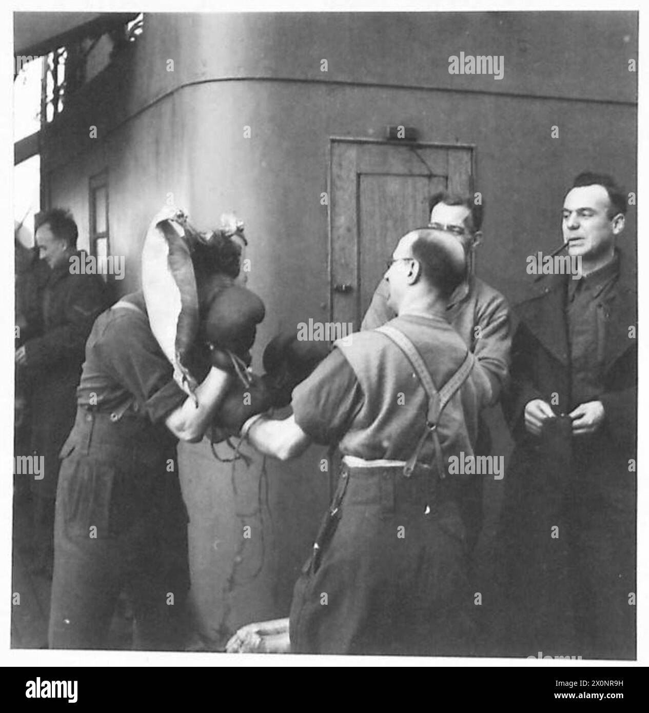 Durante la campagna di Tunisia dal novembre 1942 al maggio 1943, i rinforzi britannici a bordo di una nave da trasporto della Royal Navy parteciparono ad una partita di pugilato. Sapper Worboys dei Royal Engineers usò il suo giubbotto di salvataggio Mae West come protezione per le orecchie mentre gareggiava con un compagno di squadra. Foto Stock