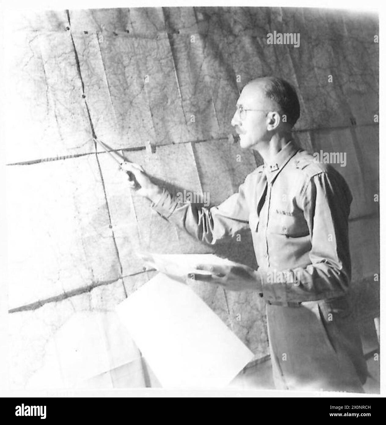Il capitano A.C. Pennoyer indica le città su una mappa dell'Italia dove si trovano preziose collezioni culturali, utilizzate per guidare le operazioni dell'aeronautica ed evitare di bombardare queste aree. Negativo fotografico, British Army. Foto Stock