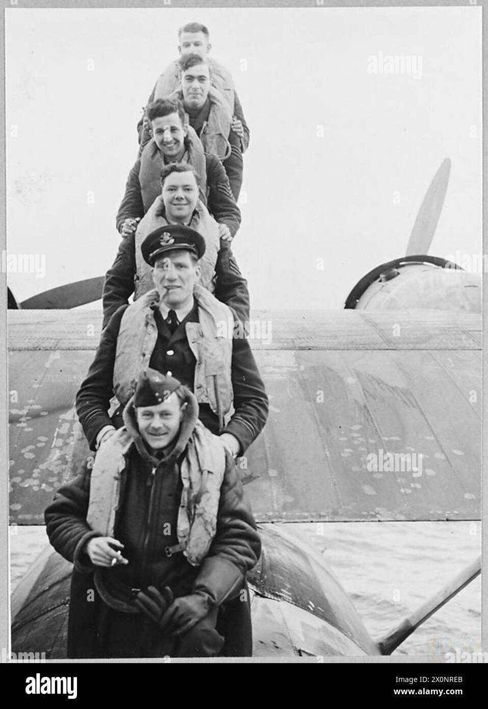 NUOVA PROTEZIONE PER I CONVOGLI: Campione dei pesi massimi e equipaggio. Era il Metropolitan Heavyweight Boxing Champion e ora sta eliminando gli U-Boot tedeschi con cariche di profondità, dal suo idrovolante Catalina. Viene visto qui con il suo pilota ufficiale e l'equipaggio. Negativo fotografico, Royal Air Force Foto Stock