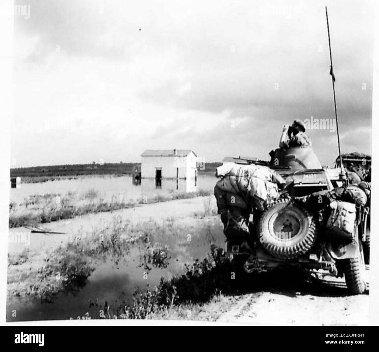 Un'auto Reece passa attraverso terreni allagati causati dal fiume Volturno che si rompe le sue sponde durante le operazioni dell'esercito britannico nella seconda guerra mondiale. Foto Stock