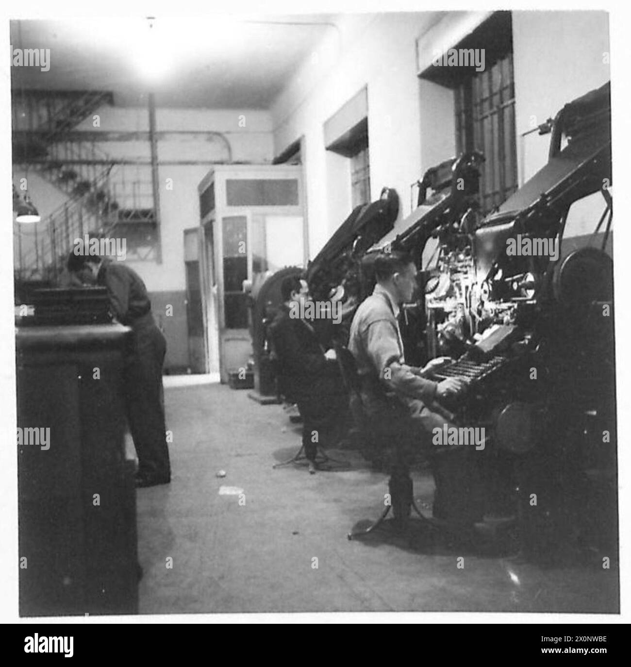 Il sergente Cochran è seduto al linotype nella sala macchine mentre produce giornali per l'Ottava Armata in Italia. Foto Stock