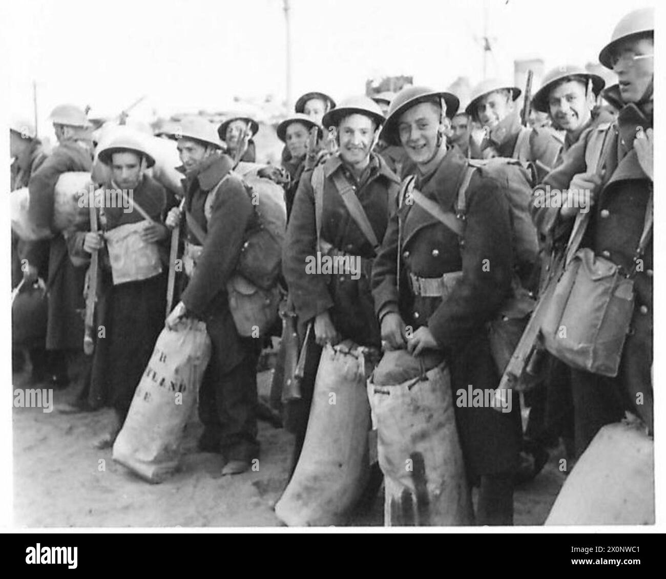 Negativo fotografico che mostra le truppe britanniche che si radunano sulla banchina e si preparano per l'imbarco a Tobruk. Foto Stock