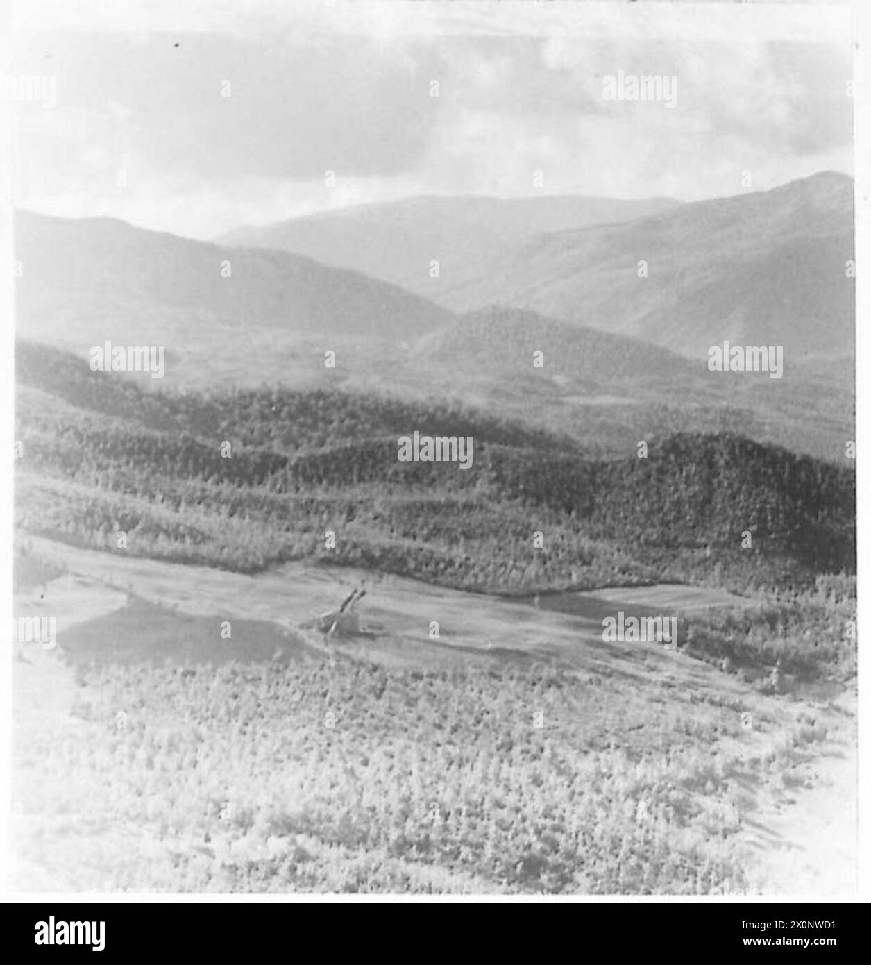 Sono mostrate colline tenute dal nemico sul fianco occidentale della 6th S.A. Armoured Division, con le cime delle montagne parzialmente oscurate dalle nuvole. Foto Stock