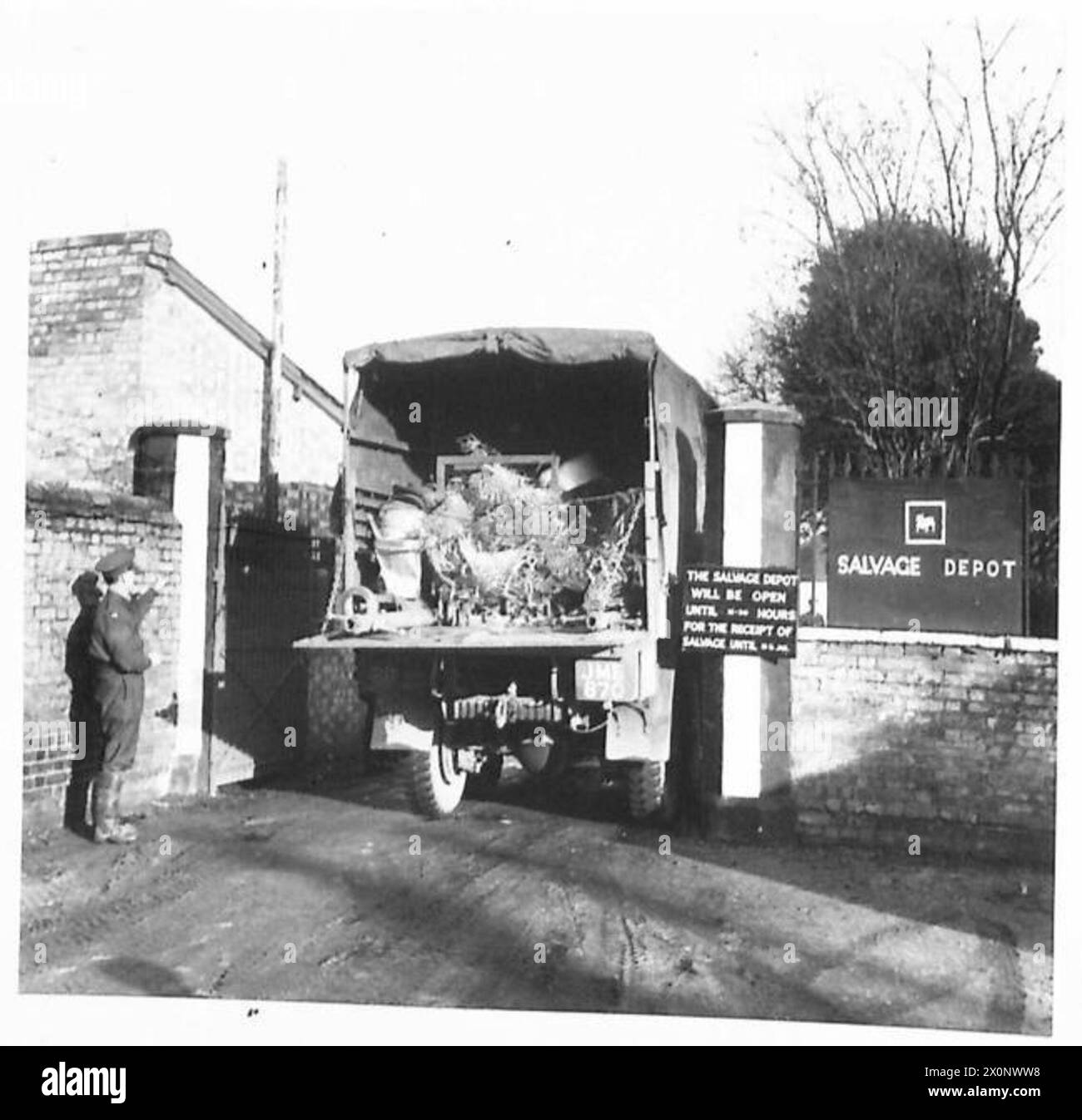 Un camion carico di materiali recuperati entra in un deposito come parte delle operazioni di salvataggio dell'esercito. Negativo fotografico, British Army. Foto Stock