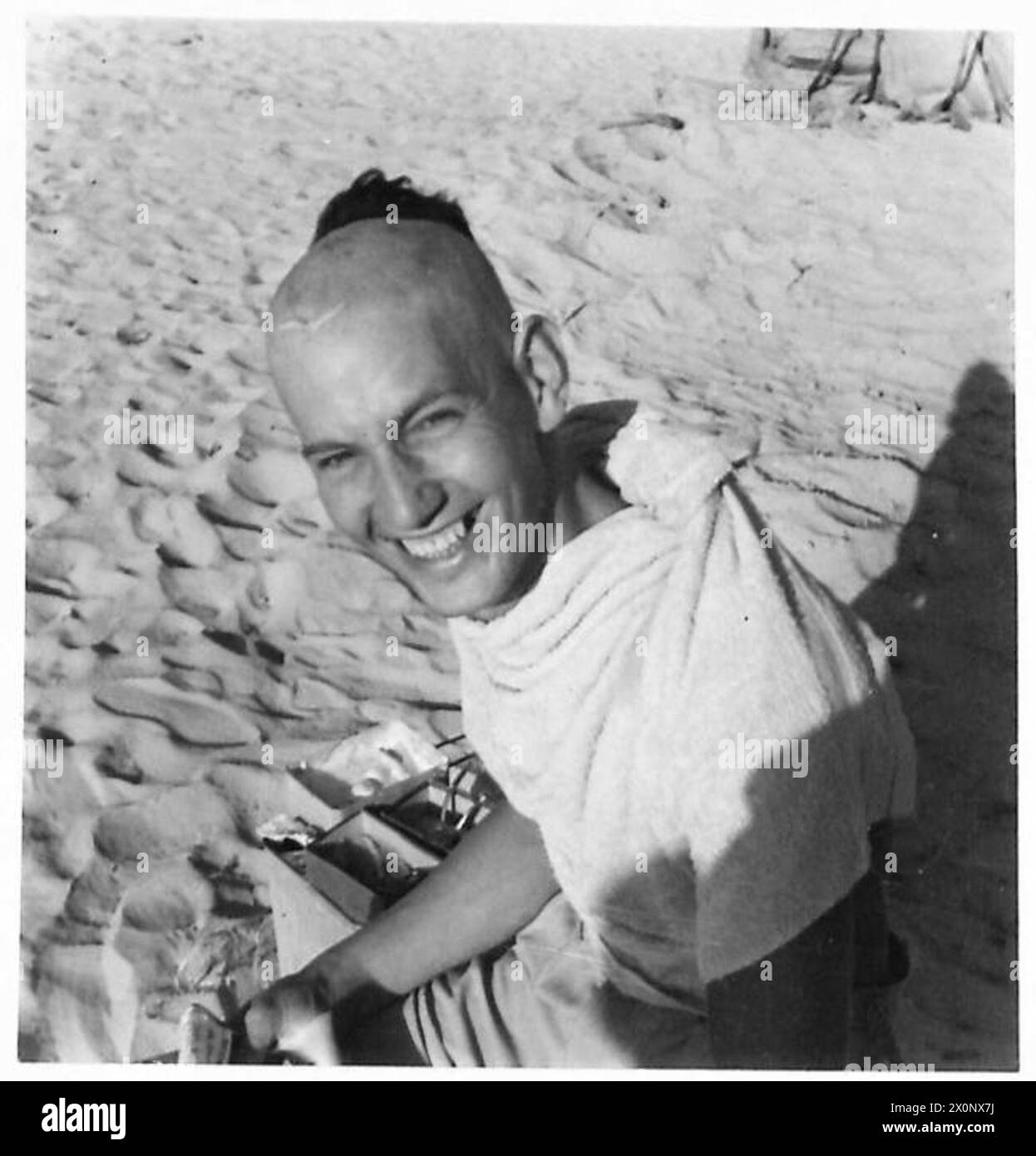 Un soldato dell'esercito britannico ha un piccolo ciuffo mentre completa una rasatura sul campo. Negativo fotografico, British Army. Foto Stock