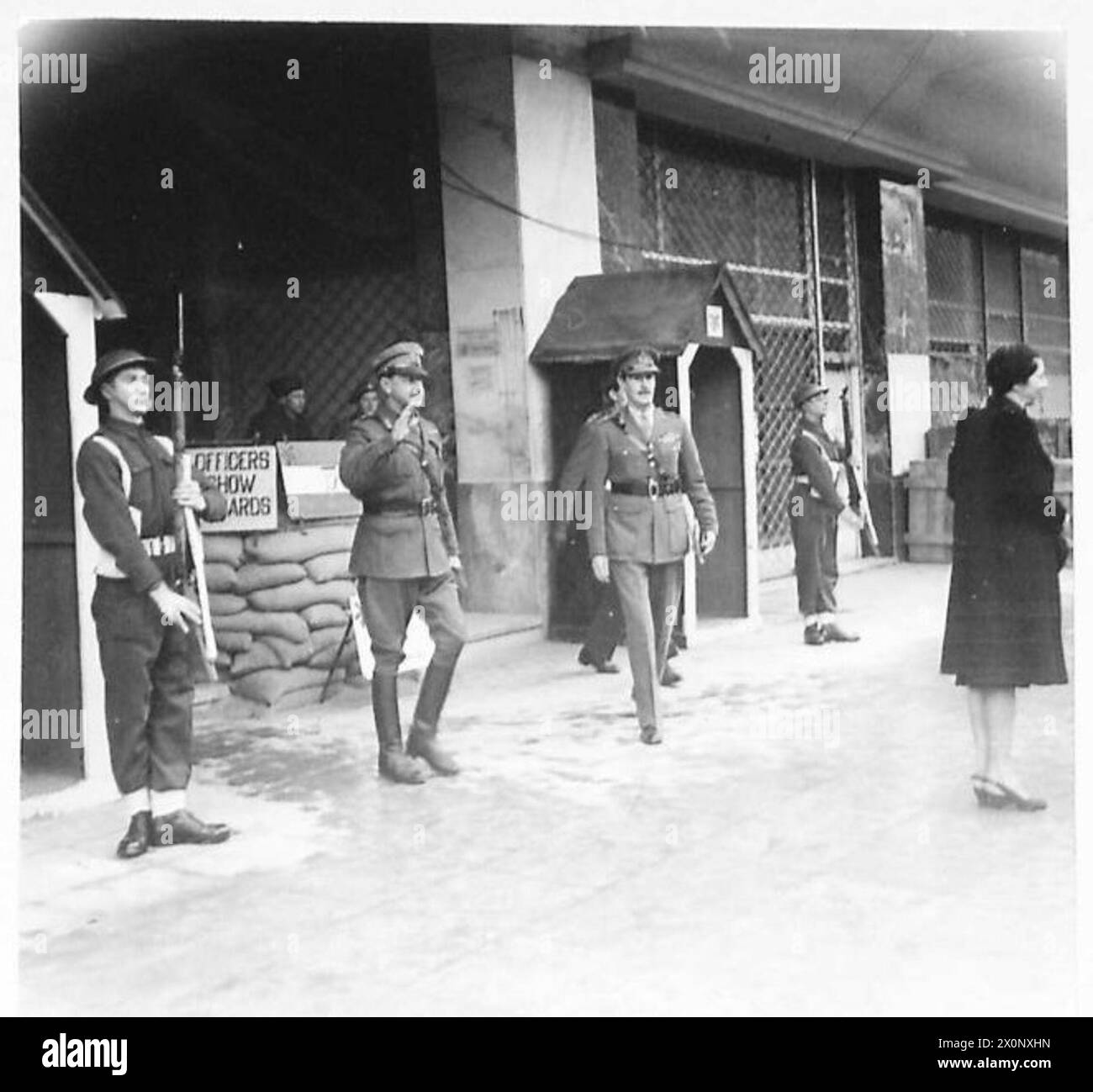 Il feldmaresciallo Alexander lascia il quartier generale del corpo ad Atene, riconoscendo le sentinelle mentre è accompagnato dal tenente generale Scobie per partecipare a un servizio presso la Chiesa inglese. Le sentinelle hanno ripreso le funzioni di guardia dopo l'implementazione operativa. Foto Stock