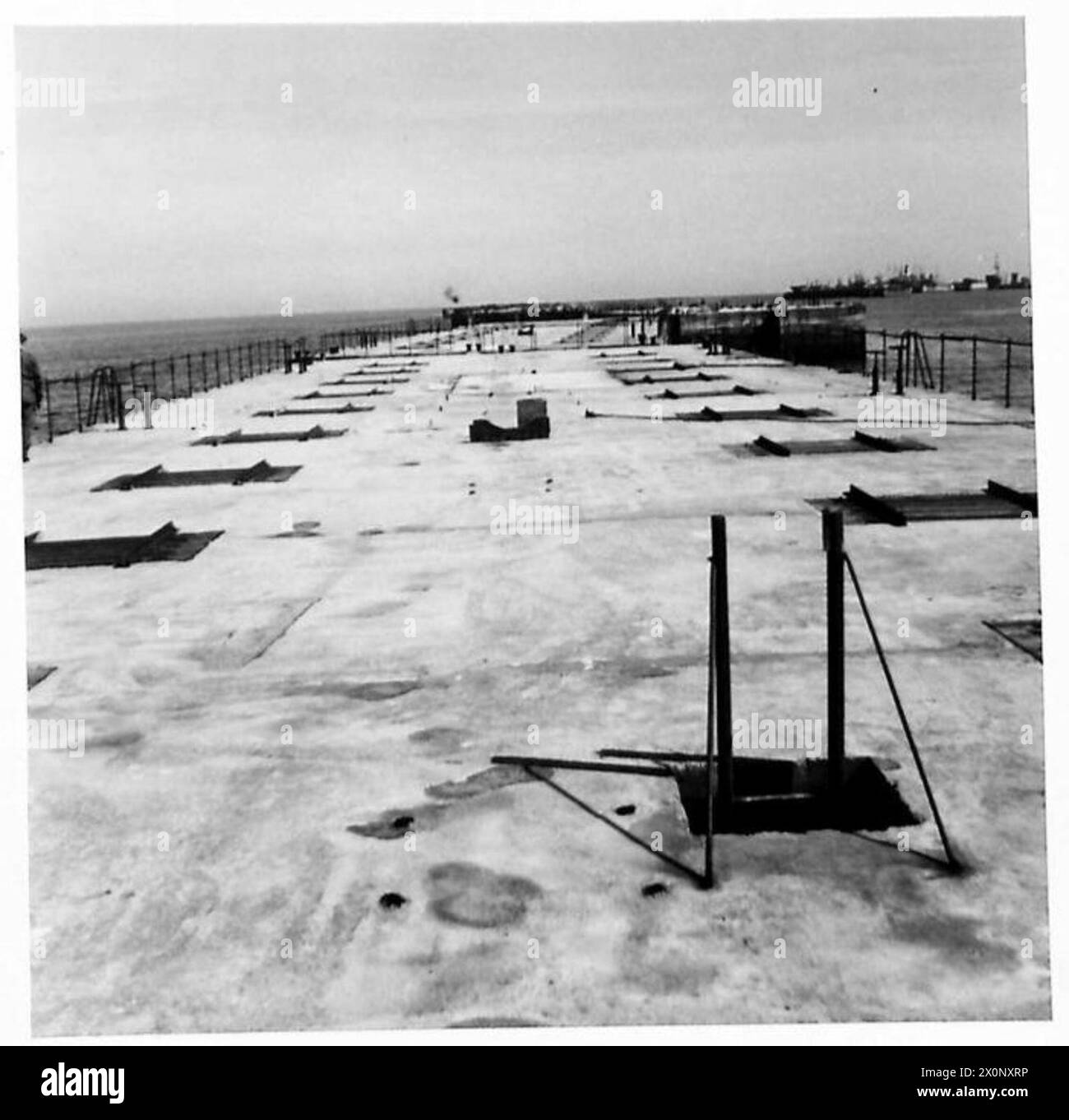 La fotografia mostra le vedute del Mulberry Port 'B' ad Arromanches dal livello del mare. L'immagine è un negativo fotografico, associato all'esercito britannico. Foto Stock