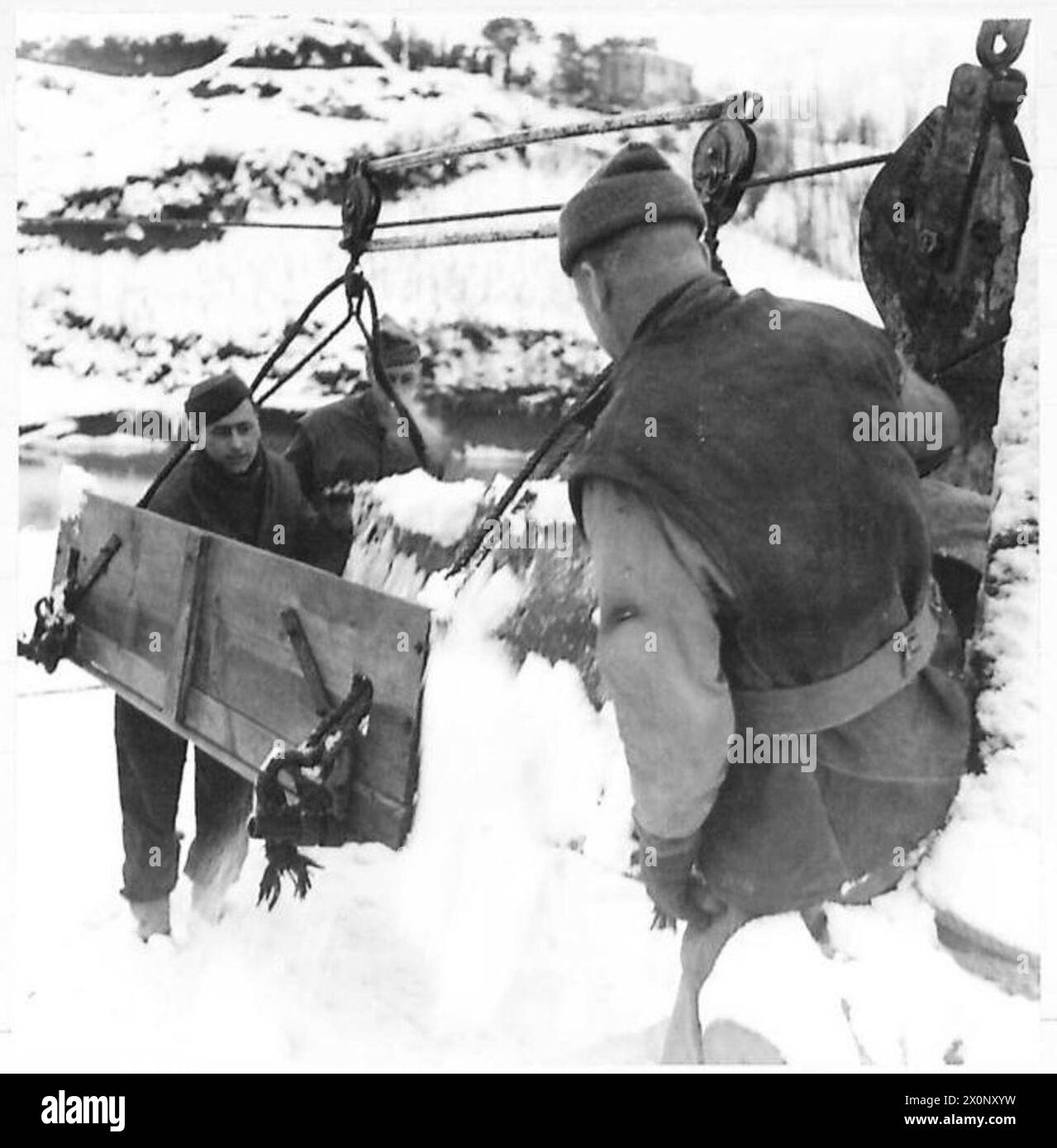 Il personale della quinta Armata svuota le barelle innevate su una culla di funivia aerea utilizzata per trasportare le vittime di battaglia attraverso il fiume Santerno a Fountanelice, in Italia, durante la seconda guerra mondiale Foto Stock