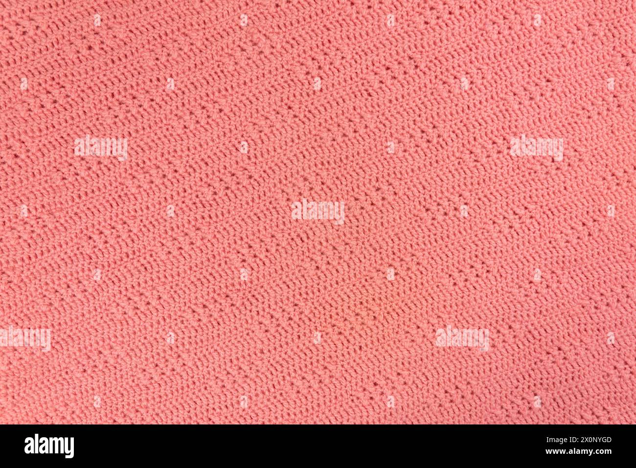 Texture e motivo di un pullover in lana rosa lavorato a maglia. Sfondo di caldo tessuto di lana fatto a mano. Foto Stock