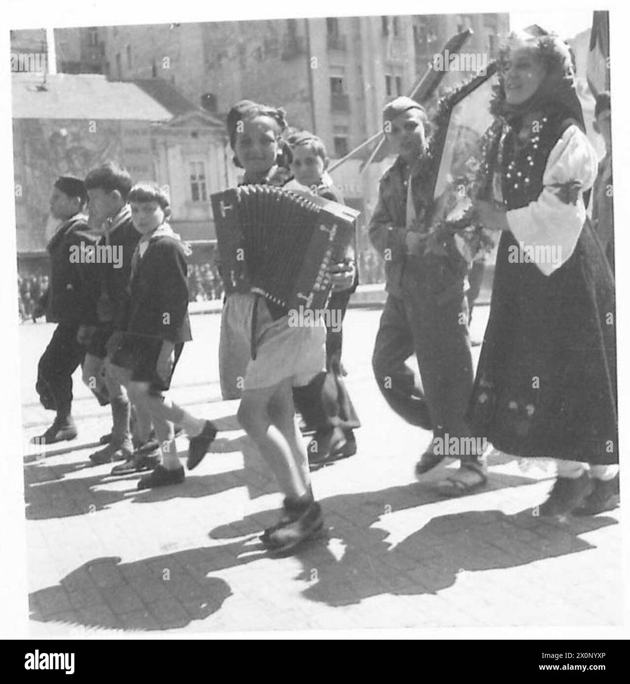 Un giovane musicista suona la fisarmonica al pianoforte durante una parata del giorno di maggio a Belgrado. Fotografato dall'esercito britannico. Foto Stock