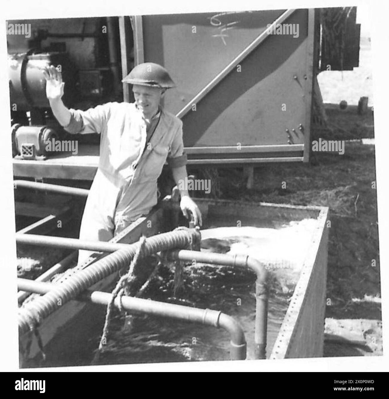 Alla testa di ponte di Anzio, una lavanderia mobile britannica utilizza l'acqua di un pozzo per riempire un serbatoio statico, da cui i rimorchi aspirano l'acqua con le loro pompe. Foto Stock